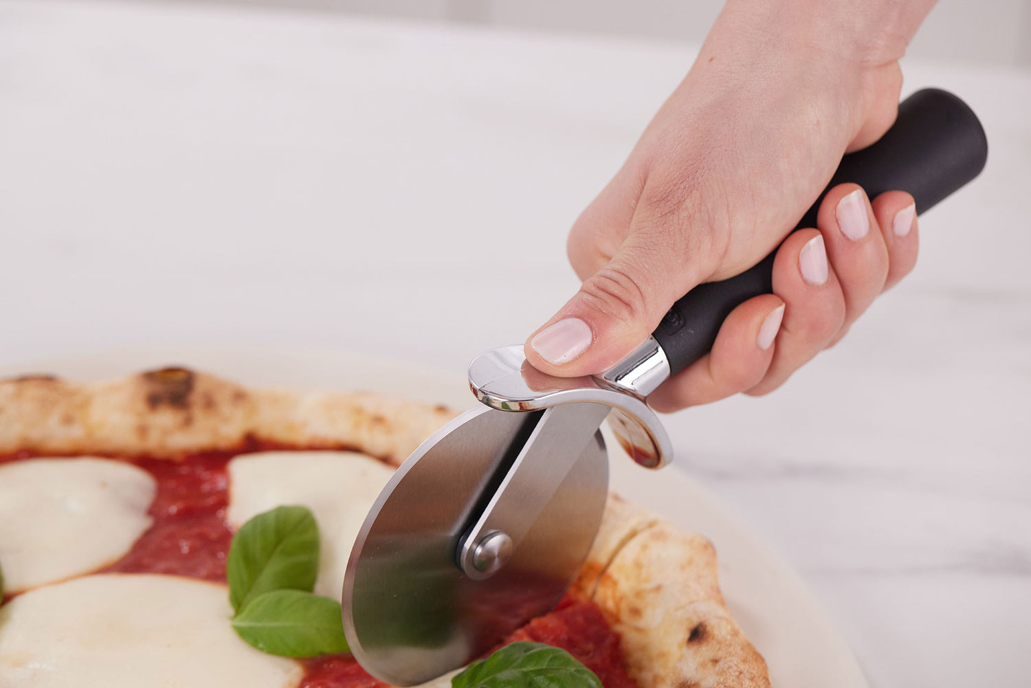 Hand slicing pizza with a Gorilla Grip pizza cutter, precise and easy to handle