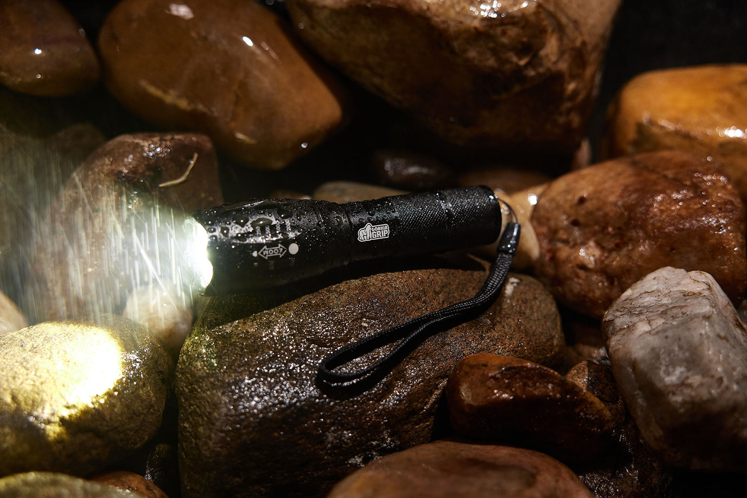 A Gorilla Grip flashlight shines on wet rocks, showcasing durability and brightness