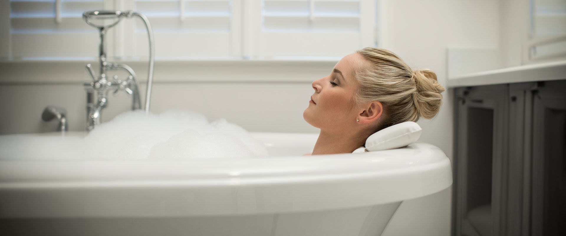 Woman relaxing in a bathtub with a Gorilla Grip bath pillow