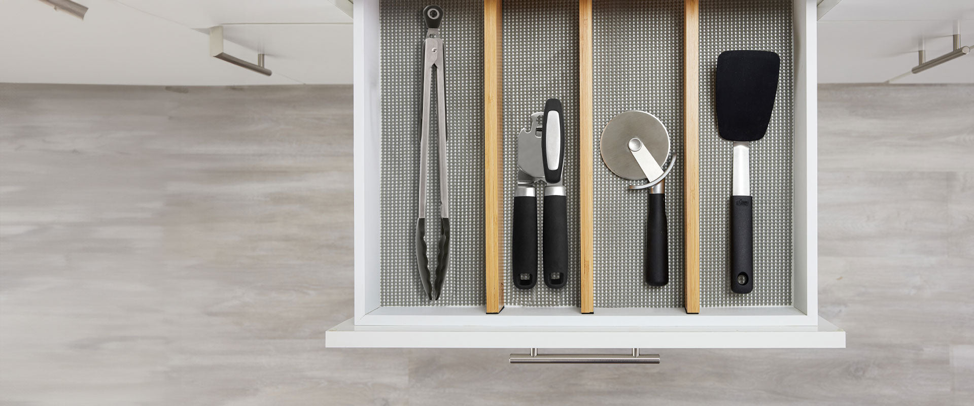 Gorilla Grip Kitchen utensils including the pizza cutter, spatula, tongs, and can opener shown in an open drawer